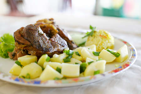 Roasted lamb plate with meat and potato saladの写真素材