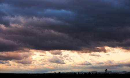 Sunset landscape with dark storm clouds after autumn rainの写真素材