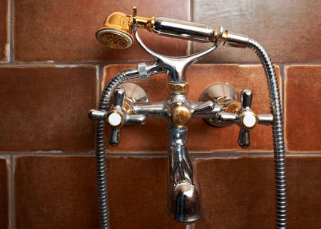 Bathroom mixing tap with shower on brown tilesの写真素材