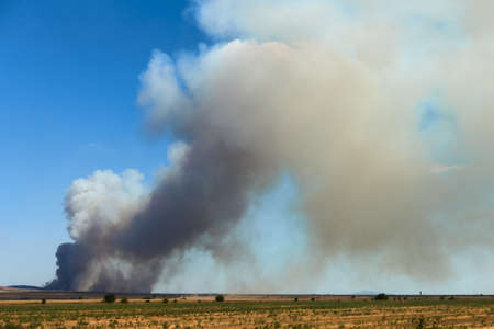 Black toxic smoke from a big industrial fire polluting the airの写真素材