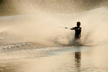 Silhouette of a barefoot skier with backlit water sprayの写真素材