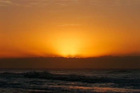 Cloud with golden lining at sunrise over the ocean 	の写真素材