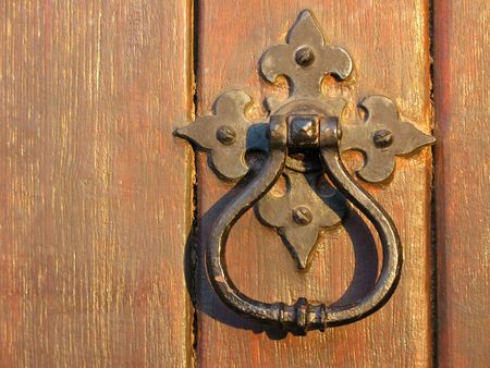 A large decorative vintage door handle on a wooden doorの写真素材