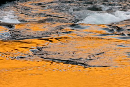 Flowing water with the reflection of the early morning light taken with a slow shutter speed の写真素材