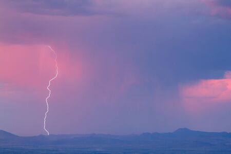 Thunderstorm with lightning and heavy rainclouds at sunset