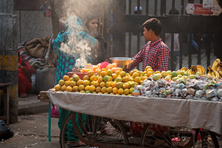 Delhi, India - November 20, 2015: An Indian boy selling his fresh produce on a crowded street market...