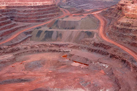 Large, open-pit iron ore mine showing the various layers of soil and iron rich oreの写真素材