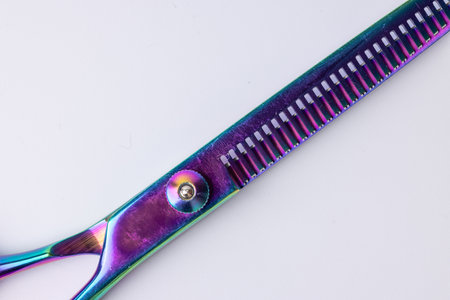 Close-up view of a pair of barber scissors, centrally positioned against a white background. The image is captured from above, emphasizing the sharpness and elegance of the scissors in a clean, crisp styleの写真素材