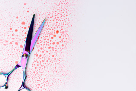 A top-down view of scissors covered in blood, positioned on a white background. The detailed focus on the blood stains emphasizes the intensity of the scene, perfect for dramatic or horror themesの写真素材
