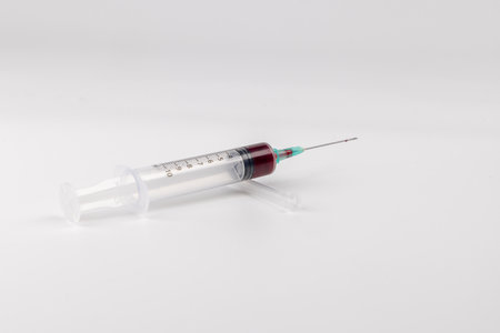 A horizontal shot of a syrinx filled with blood, prominently positioned in the center of a clean white backgroundの写真素材