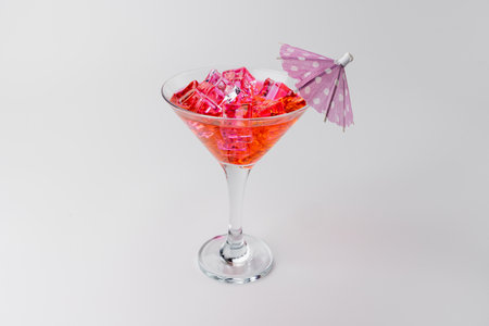 Horizontal top view of a pink cocktail with plenty of ice, garnished with a paper umbrella. The drink is centered on a white background, creating a vibrant, refreshing lookの写真素材