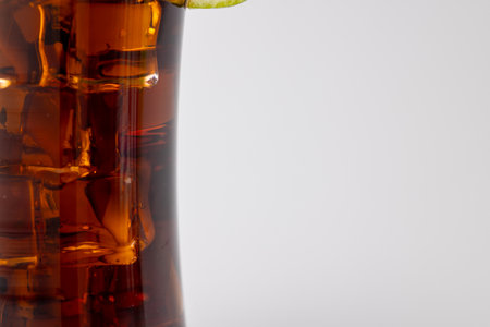 Detailed view of a cola drink with ice, a lemon slice, and a purple straw in the center of the image