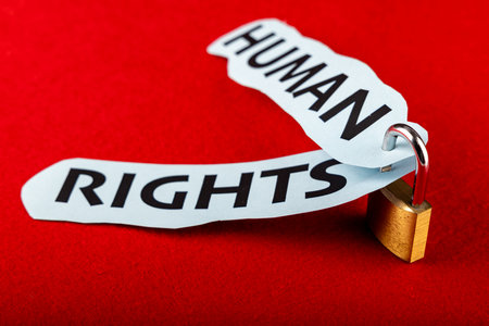 In the center, a padlock clasps two papers with "human rights" written, set against a striking red backdrop, embodying securityの写真素材