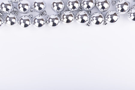 A captivating display of silver holiday balls at the top, evoking a festive atmosphere with a bright and airy feelの写真素材