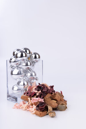 A chic glass jar overflowing with silver Christmas balls, paired with rustic dried flowers, perfect for elevating your holiday decorの写真素材