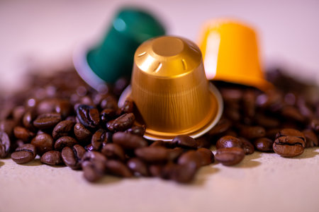 Colorful coffee capsules over a pile of roasted coffee beans. Perfect for coffee loversの写真素材