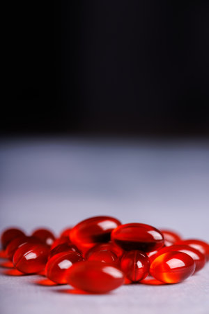 A detailed shot of red transparent pills placed on a concrete surface, with a black background...