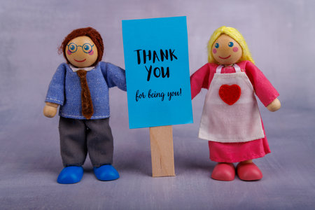 The wooden toys a man and woman happily present a blue banner with an uplifting message, capturing a spirit of positivity and encouragementの写真素材