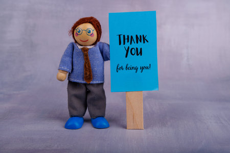 This charming wooden toy displays a bright blue sign with a motivational message, encouraging self-confidence and joy in a playful wayの写真素材