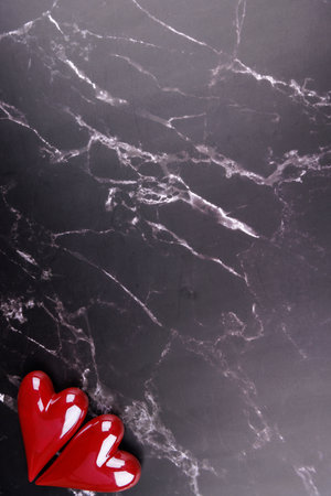 Romantic red and white porcelain hearts on a black marble surface, photographed from above to capture the Valentine's Day moodの写真素材