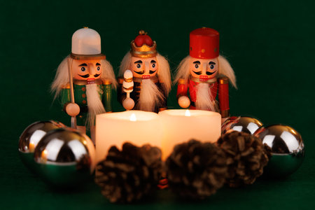 A joyful nutcracker with original hair stands beside lit candles and holiday decorations, creating a...