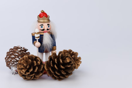 This festive wooden nutcracker, adorned with original hair, is beautifully complemented by pine cones, creating a charming holiday displayの写真素材