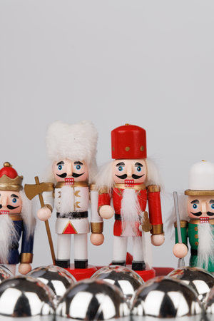A nostalgic pair of wooden nutcrackers with original hair stands next to silver Christmas ornaments,...