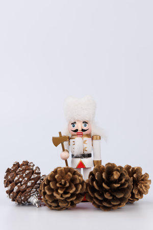 A nostalgic wooden nutcracker with original hair stands next to decorative pine cones, capturing the essence of Christmas in a charming displayの写真素材