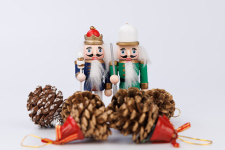 This joyful wooden nutcracker duo, adorned with original hair, is complemented by pine cones, creating a delightful scene for Christmas celebrationsの写真素材