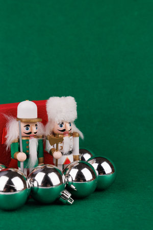 This charming nutcracker and plush bear sit beside a vibrant red present, beautifully complemented...