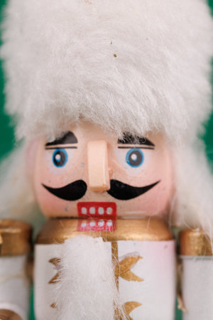 A classic nutcracker with original hair and festive ornaments is beautifully displayed on a lush green background, perfect for Christmasの写真素材