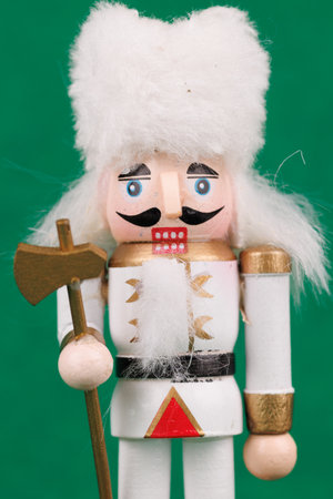 A festive nutcracker with original hair and colorful ornaments is beautifully set against a green canvas, enhancing holiday ambianceの写真素材