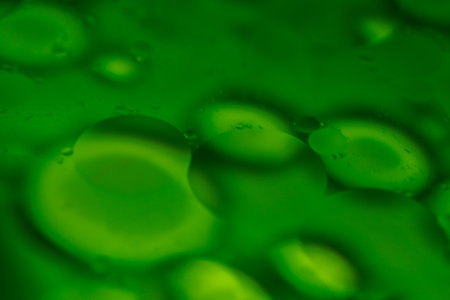 Oil droplets float in water, interacting with colors to form fluid and vibrant abstract patterns...