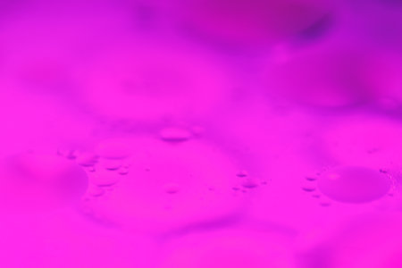 Bubbles of oil float in water, blending with vibrant colors to form unique abstract patterns, creating a visually stunning and dynamic design.の写真素材