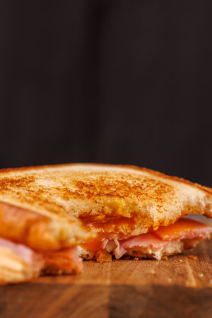 A delightful half-eaten egg, ham, and cheese sandwich sits atop a vertical tower, beautifully...