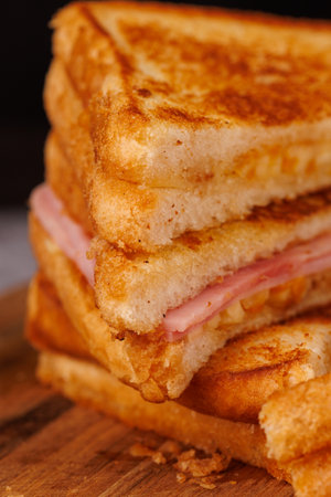 A satisfying selection of ham and cheese sandwiches stacked vertically, elegantly presented on a...