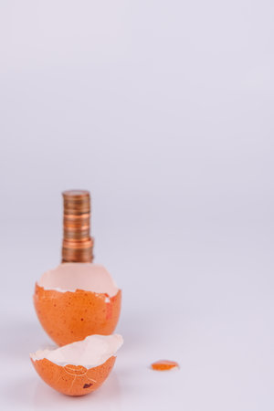 A visual metaphor of eggshells and copper coins reflecting the economic impact of higher egg pricesの写真素材