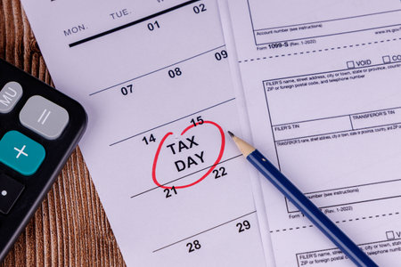 A professional desk with a red-circled April 15th calendar, calculators, and pencils, emphasizing 1099 form completionの写真素材