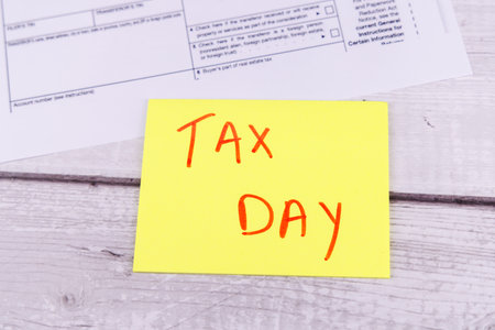April 15 tax filing reminder with financial supplies and tax form 1099 on tableの写真素材