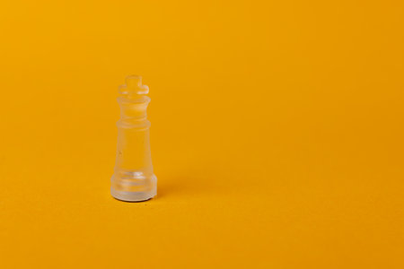 Majestic chess king piece on a bold yellow background, illustrating dominance, intellect, and tactical mastery in competitive chess gameplayの写真素材