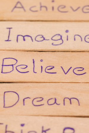 Simple, positive words carved in wood placed on the grass, symbolizing hope and clarityの写真素材