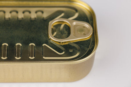 Shiny gold food tin can resting on a white background, symbolizing durability, quality, and long-term food preservation.の写真素材