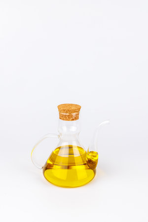 Elegant oil dispenser filled with olive oil. Isolated on white, ideal for illustrating Mediterranean diet or organic cooking themes.の写真素材