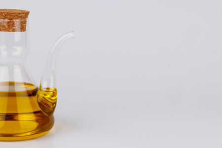 Minimalist glass cruet with olive oil on a white background. Perfect for clean, modern food or diet stock images.の写真素材