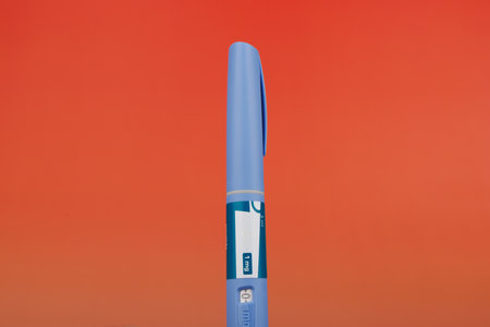 A horizontal semaglutide injector on a red gradient backdrop, perfect for illustrating modern diabetes or obesity treatment solutionsの写真素材
