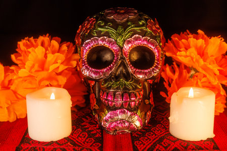 A flower-painted black skull with magnolias and candles decorates an altar with a traditional...