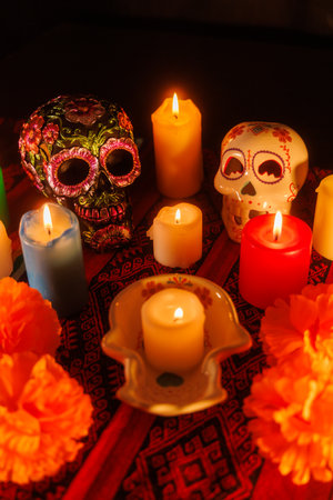 Vibrant altar with two skulls, glowing candles and magnolia blossoms celebrating Mexico's Day of the Dead traditionの写真素材
