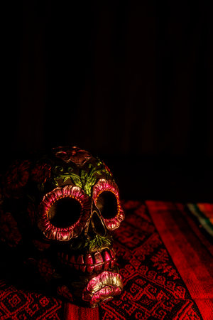 Floral black skull resting on a traditional tablecloth. An offering to remember departed souls on...