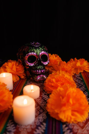 Festive altar featuring black skull with flower decorations, surrounded by colorful candles and...
