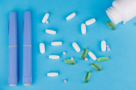 Blue tape measure and semaglutide pens with scattered pills on blue table, symbolizing health careの写真素材